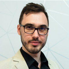 a man wearing glasses and a suit jacket